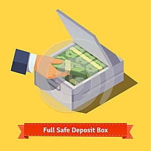 Hands putting cash stack to a safe deposit box