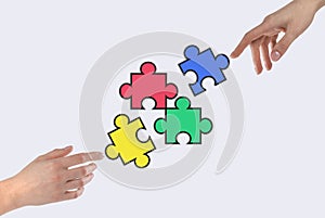 Hands putting colorful puzzle pieces together. Partnership, cooperation, teamwork concept. Finding solution from