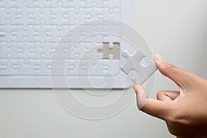 Hands putting piece to white jigsaw puzzle,Success mosaic solution template,Concept partnership business successful teamwork photo