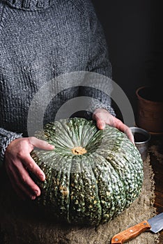 Hands Putting Ripe Green Pumpkin on Table