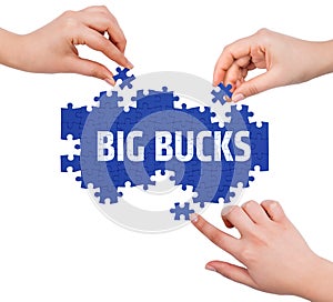 Hands with puzzle making BIG BUCKS word