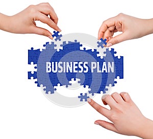 Hands with puzzle making BUSINESS PLAN word