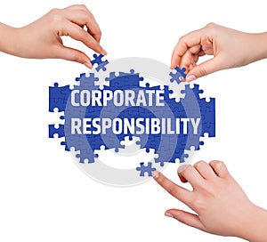 Hands with puzzle making CORPORATE RESPONSIBILITY word