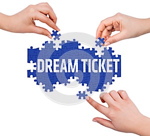 Hands with puzzle making DREAM TICKET word