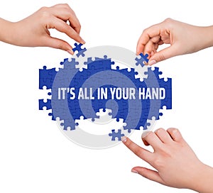 Hands with puzzle making ITâ€™S ALL IN YOUR HAND word