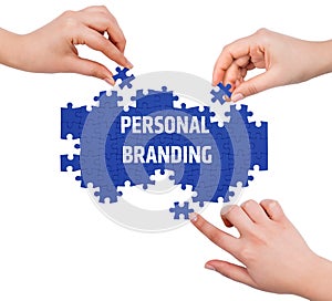 Hands with puzzle making PERSONAL BRANDING word