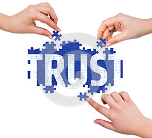 Hands with puzzle making TRUST word photo