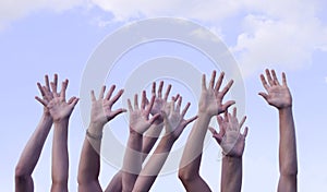 Hands Raised in Air Against Sky