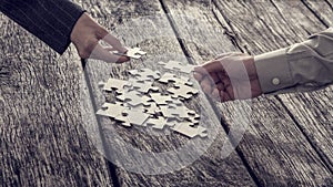 Hands reaching for puzzle pieces