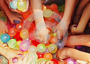 Hands reaching for water balloons