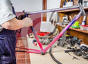 Hands of real bicycle mechanic cleaning frame bike