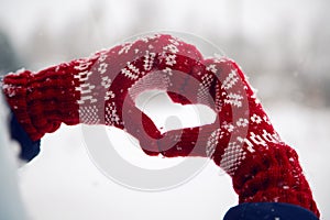 Hands in red mittens folded heart photo