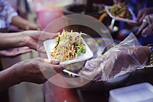 The hands of refugees have been aided by charity food to alleviate hunger : Feeding Concepts : Hand offered to donate food from a