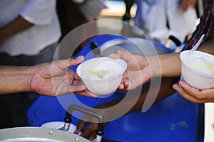 The hands of refugees have been aided by charity food to alleviate hunger : Feeding Concepts : Hand offered to donate food from a