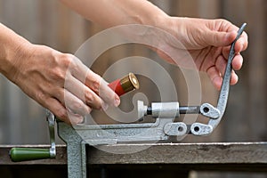 Hands reloading cartridge by shotgun shell reloader