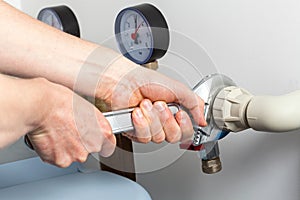 Hands repairing valves in boiler room photo