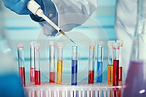 Hands of a researcher pipetting liquid samples in tubes test