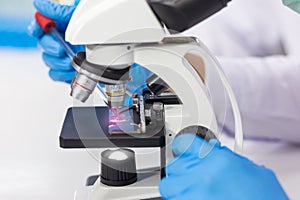 The hands of a researcher using a microscope to work in the laboratory