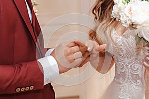 Hands with rings Groom putting golden ring on bride`s finger