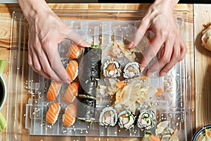 hands rolling a temaki roll on a clear cutting board