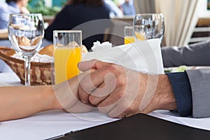 Hands of romantic couple over a restaurant table