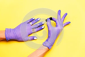 Hands in rubber gloves painting nails. Coromavirus concept