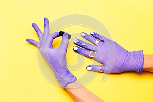 Hands in rubber gloves painting nails. Coromavirus concept