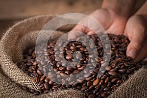 Hands on a sack of coffee beans