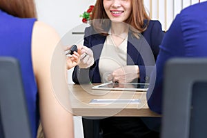 Hands of sales car dealership giving keys to customer