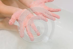 Hands with salt Dead Sea in bath