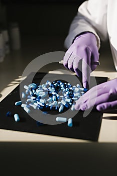 Hands of a scientist working with capsules