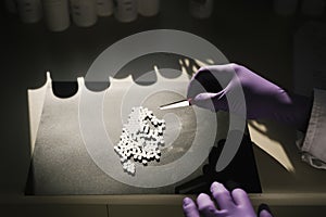 Hands of a scientist working with some pills