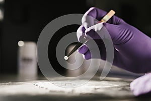 Hands of a scientist working with some pills