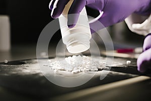 Hands of a scientist working with some pills