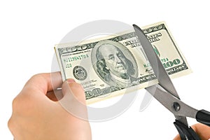 Hands with scissors cutting money