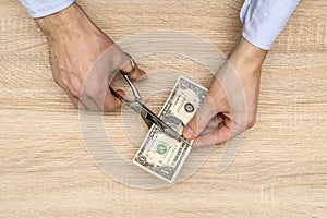 Hands with scissors cutting money