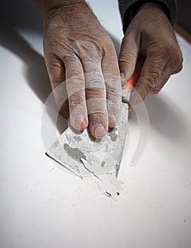 Hands scraping paint