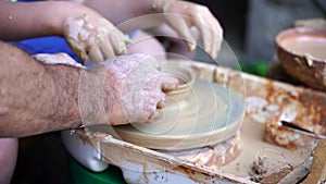 Hands sculpt clay with their own hands to create homemade zero-waist toys. Creative lesson on the Potter`s wheel of
