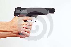 Hands with semi-automatic handgun on white background