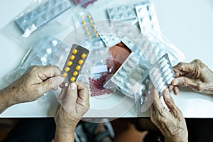 Hands of senior female patients holding medicine pill and capsules,asian old people with chronic illness is carrying medication to