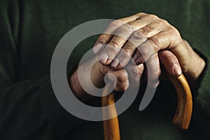 Hands of a senior man clasping a cane