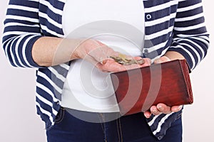 Hands of senior woman with coins and leather wallet, concept of financial security in old age
