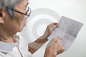 Hands of senior woman holding saving account passbook,checking the sum of money kept and check the amount of elderly pension and photo