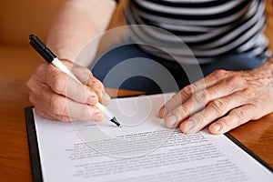 Hands of senior woman signature document