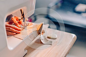 Hands of sewing process. Female hands stitching fabric.