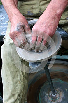 Hands shaping clay on potter's wheel photo