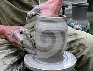 Hands shaping clay on potter's wheel photo