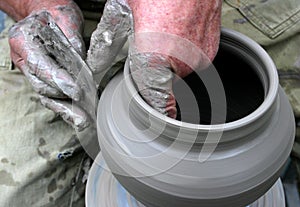 Hands shaping clay on potter's wheel photo