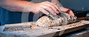 Hands shaping und kneading dough with grains