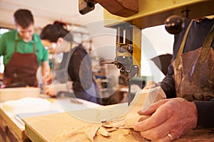 Hands of shoemaker shaping shoe lasts in a workshop